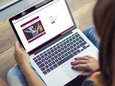 Frau schaut auf einen Laptop auf dem die Applikation zur Verwaltung der Geräteinitiative geöffnet ist