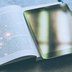 Ein Buch und ein Tablet sind abgebildet