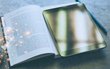 Ein Buch und ein Tablet sind abgebildet