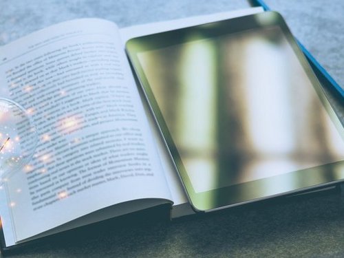 Ein Buch und ein Tablet sind abgebildet