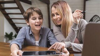 Erziehungsberechtigte und Sohn mit Tablet und Laptop