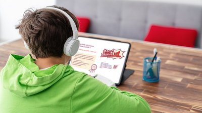 Young boy is studying in front of the laptop.