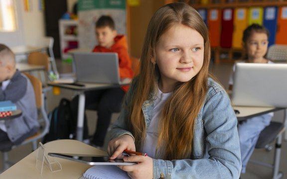 Kinder in der Schule mit digitalen Geräten