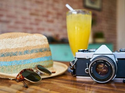 Graue Und Schwarze Dslr Kamera Neben Sonnenhut Und Sonnenbrille